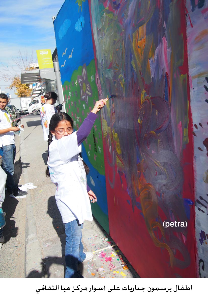 اطفال يرسمون جداريات على اسوار مركز هيا الثقافي