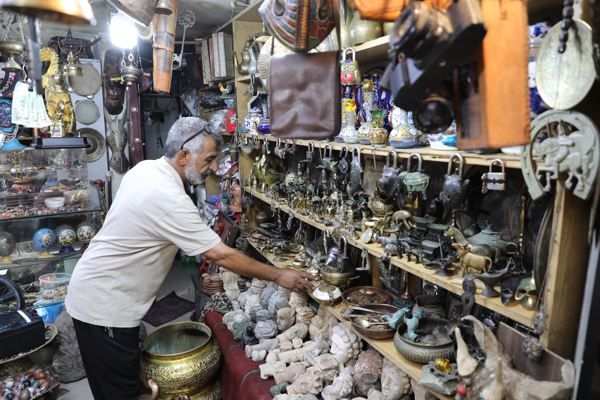 تاجر يقوم بترتيب بضاعته في احد محلات النحاسيات والقطع الاثرية التي تشهد اقبالا من زوار المملكة  تصوير: علي الزعبي